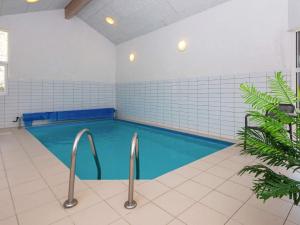 a swimming pool with blue water and white tiles at 10 person holiday home in L gst r in Trend