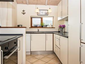 een keuken met witte kasten en een wastafel bij 8 person holiday home in Ulfborg in Thorsminde