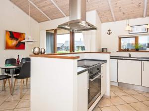 a kitchen with white cabinets and a table and a stove at 8 person holiday home in Ulfborg in Thorsminde