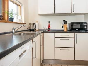 een keuken met witte kasten en een wastafel bij 8 person holiday home in Ulfborg in Thorsminde