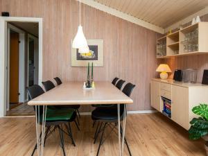 a dining room with a wooden table and chairs at 6 person holiday home in Hemmet in Hemmet