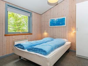 een slaapkamer met een bed met blauwe kussens erop bij 8 person holiday home in B rkop in Børkop