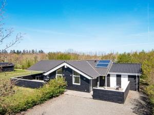 una casa nera con un pannello solare sul tetto di Four-Bedroom Holiday home in Hemmet 7 a Falen