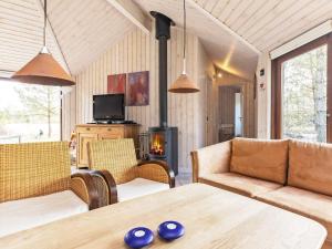 a living room with a table and chairs and a fireplace at 8 person holiday home in Fjerritslev in Torup Strand