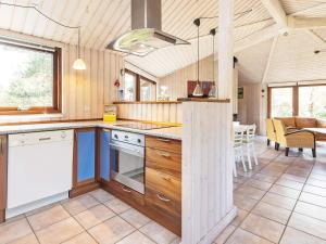 cocina con armarios de madera y comedor en 8 person holiday home in Fjerritslev en Torup Strand