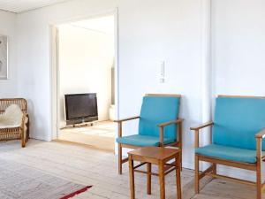 uma sala de estar com duas cadeiras azuis e uma televisão em Holiday home Sjællands Odde XVII em Havnebyen