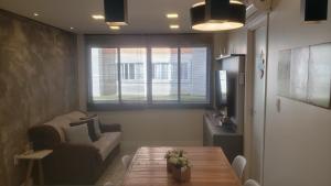 un salon avec une table et un canapé dans l'établissement Apartamento Aconchegante Esteio - Coração da Grande Porto Alegre, à Esteio