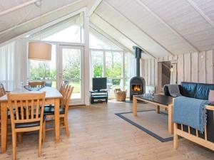 a living room with a table and a fireplace at 8 person holiday home in Hemmet in Hemmet