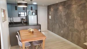 une salle à manger avec une table et des chaises en bois dans l'établissement Apartamento Aconchegante Esteio - Coração da Grande Porto Alegre, à Esteio