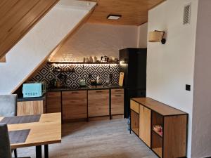 kuchnia z drewnianymi szafkami i czarną lodówką w obiekcie Apartament Nova Kamienica 2 w Łagowie