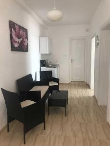 a living room with two tables and chairs and a kitchen at Suka Apartments in Ulcinj +24 photos