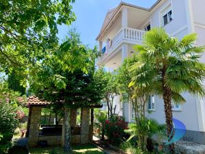 a large white building with trees in front of it at VeLa Apartments in Ičići