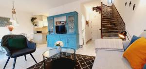 uma sala de estar com um armário azul e uma mesa de vidro em Villa charmosa V2 junto à praia e à Marina de Vilamoura em Quarteira
