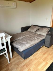 Bett in einem Zimmer mit einem Schreibtisch und einem Bett der Marke sidx sidx sidx. in der Unterkunft Cozy apartment in Tórshavn, Faroe Island with free parking. in Tórshavn