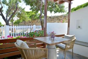 une table et des chaises sur une terrasse avec une clôture blanche dans l'établissement Niriis Studio 7 Batsi Andros, à Batsi