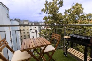 balkon z drewnianym stołem i fortepianem w obiekcie Deluxe apartment near hauptbahnhof w Wiedniu