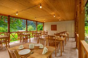 a restaurant with wooden tables and chairs and windows at Chiora Inn in Chiora +26 photos