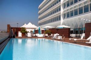 una grande piscina di fronte a un edificio di Hotel Hiberus a Saragozza