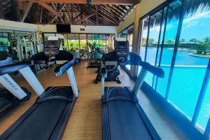 een fitnessruimte met 2 loopbanden en uitzicht op het water bij Vg Sun Cumbuco Vista Mar Pertinho Praia in Caucaia