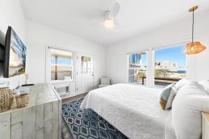 Dormitorio blanco con cama y ventana grande en The Hideaway Hotel, en Long Beach
