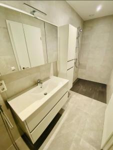 ein weißes Badezimmer mit einem Waschbecken und einem Spiegel in der Unterkunft Brand New 2 bedrooms with Parking and Terrace - 142-96 in Luxemburg (Stadt)