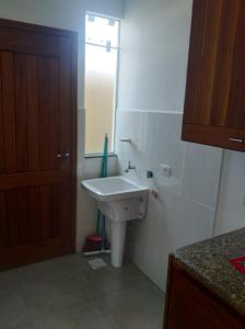 a bathroom with a white sink and a mirror at Cs9 Casa de 3 quartos a 15 min de Curitiba in Campina Grande do Sul