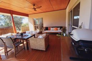 a living room with a table and chairs and a grill at Serenity in Style in Kalbarri