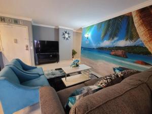 a living room with a couch and a mural of a beach at Lovely Condo 2 Bedrooms, 2 bathrooms, free 1 Parking at Waikiki Beach in Honolulu