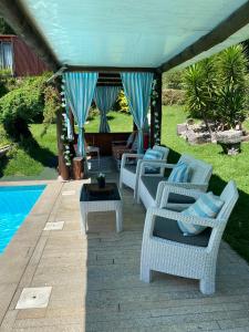 un grupo de sillas y una mesa junto a una piscina en Quinta Leiras de Mondim, en Pico