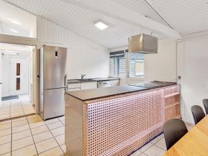 Kongsmarkにある8 person holiday home in R mのキッチン(ステンレス製の冷蔵庫、テーブル付)
