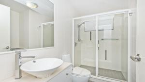 a white bathroom with a sink and a shower at Deep Blue Apartment 20 Tangalooma in Tangalooma +12 photos