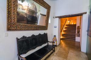 a hallway with a bench and a picture on the wall at Casa Cordoba Román in Cartagena de Indias