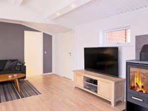 uma sala de estar com uma televisão de ecrã plano e uma lareira em Holiday home Gilleleje LXXXII em Gilleleje