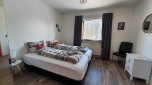 a bedroom with two beds and a window at Cora´s House & Horses in Ölfus