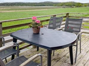 une table noire avec un pot de fleurs sur une terrasse dans l'établissement 5 person holiday home in VAREKIL, à Varekil