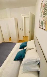 a large white bed with blue pillows in a room at Brand New Luxury 3 bedrooms, Terrace and Free Parking - noah in Luxembourg