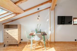 a dining room with a table and white chairs at Buhardilla de diseño en pleno centro de Santander in Santander