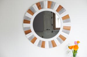 a round mirror on a white wall with flowers at Hostel Niniroom in Kyoto +51 photos