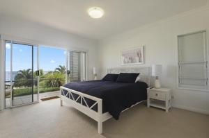 ein Schlafzimmer mit einem Bett und einem großen Fenster in der Unterkunft Deep Blue Apartment 1 Tangalooma in Tangalooma