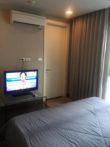 a hotel room with a bed and a television at Livat5r1042 in Makkasan