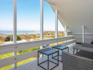 un balcone con 2 tavoli, sedie e vista sull'oceano di 7 person holiday home in Knebel a Skødshoved Strand