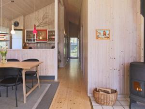 a kitchen and dining room with a table and a stove at 8 person holiday home in V ggerl se in Marielyst