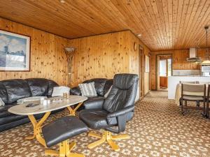 a living room with a leather couch and a table at Holiday home Roslev IV in Roslev