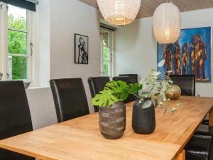 a dining room with a wooden table with plants on it at 12 person holiday home in Ulfborg in Øby
