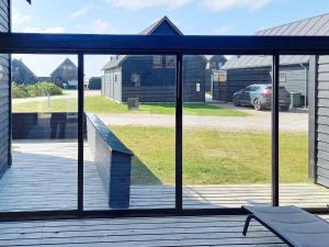a screened porch with a view of a yard at 6 person holiday home in R m in Sønderby