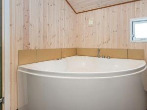 Una gran bañera blanca en una habitación con paredes de madera. en 8 person holiday home in Hejls, en Hejls