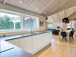 a kitchen with white cabinets and a dining room at Holiday Home Hansavej in Marielyst