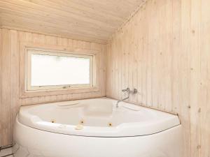 a white tub in a room with a window at 8 person holiday home in Pandrup in Blokhus