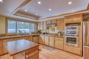 a kitchen with wooden cabinets and a large window at Mugho 10 - Meredith Lodging in Sunriver