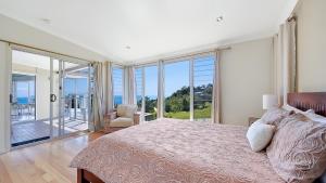 a bedroom with a large bed with a view of the ocean at Ohana Beach House in Tangalooma +25 photos